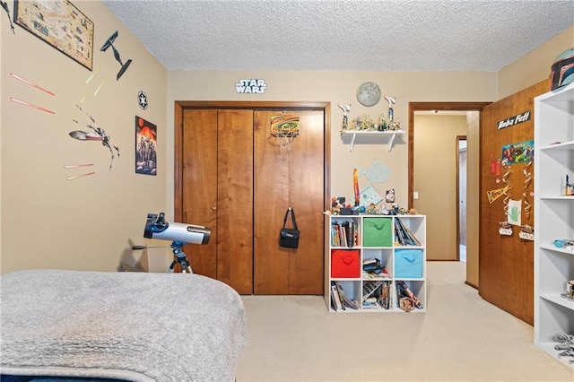 carpeted bedroom with a closet and a textured ceiling