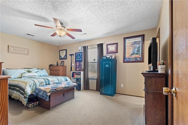 bedroom featuring visible vents, light colored carpet, a textured ceiling, and ceiling fan