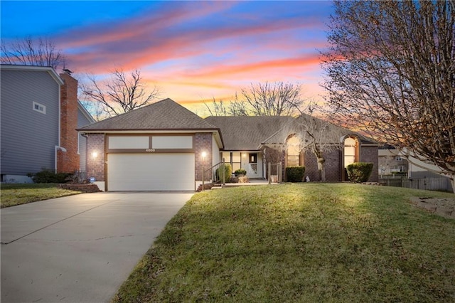 view of front of property with brick siding, concrete driveway, roof with shingles, a yard, and a garage