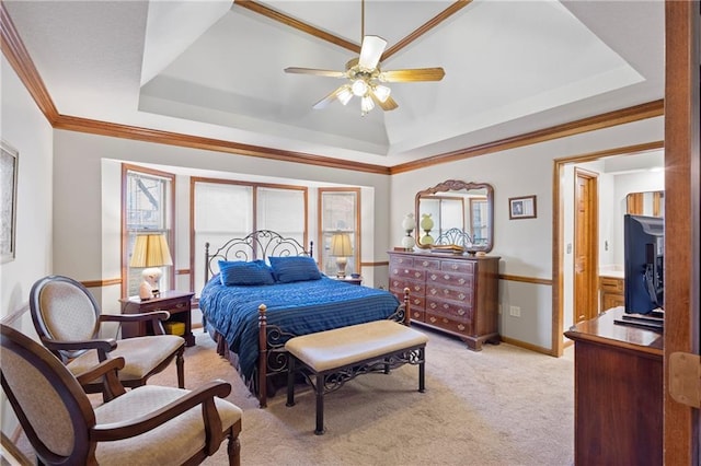 bedroom with a tray ceiling, baseboards, light colored carpet, and ornamental molding