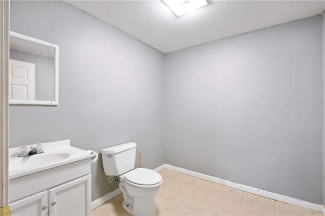 half bath featuring toilet, vanity, and baseboards