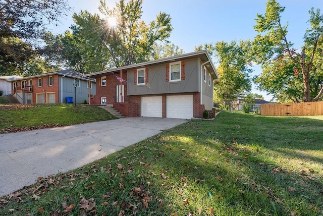 bi-level home featuring brick siding, a front lawn, fence, concrete driveway, and a garage