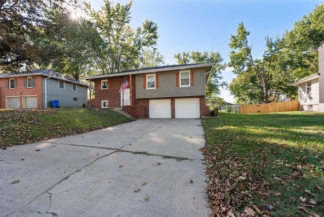 raised ranch with fence, an attached garage, concrete driveway, a front lawn, and brick siding