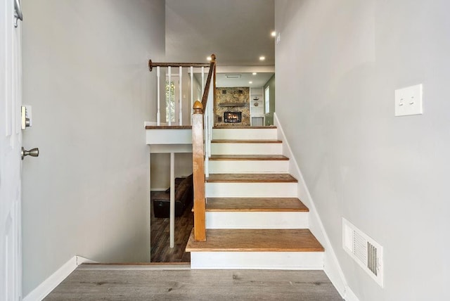 stairs featuring visible vents, baseboards, and wood finished floors