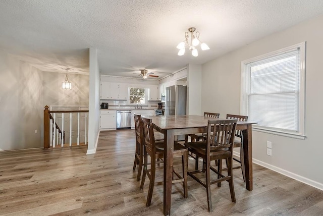 dining room featuring an inviting chandelier, wood finished floors, and a textured ceiling