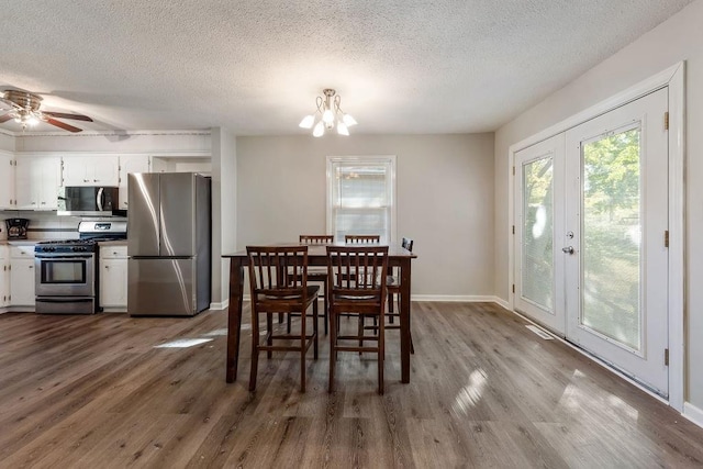 dining room featuring dark wood-style floors, french doors, a textured ceiling, and baseboards