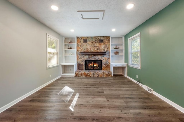 unfurnished living room featuring a healthy amount of sunlight, baseboards, and a textured ceiling