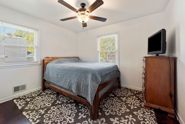 bedroom featuring visible vents, multiple windows, and baseboards