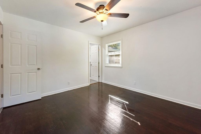 spare room featuring a ceiling fan, baseboards, and wood finished floors