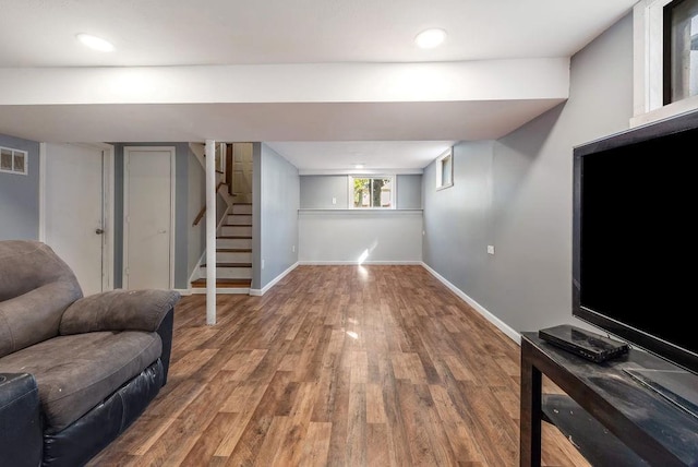 below grade area with visible vents, wood finished floors, recessed lighting, stairway, and baseboards