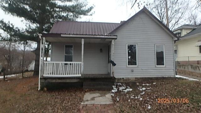 back of property with covered porch and metal roof