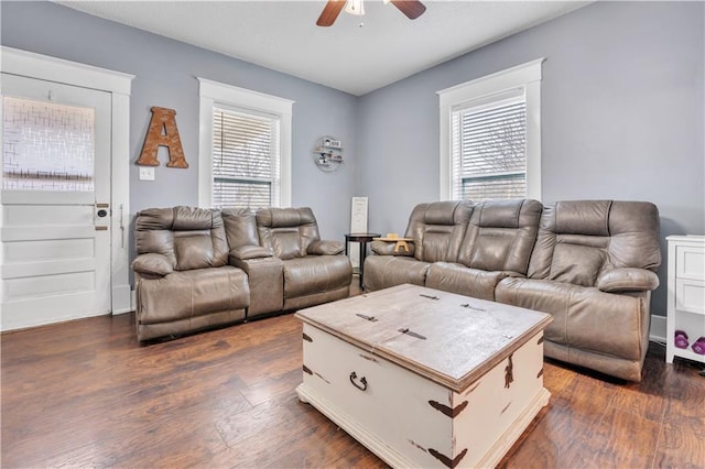 living area featuring a wealth of natural light, a ceiling fan, and dark wood-style flooring