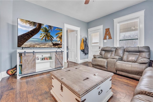 living area featuring a ceiling fan and dark wood-style flooring