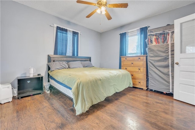 bedroom featuring ceiling fan, a textured ceiling, and wood finished floors