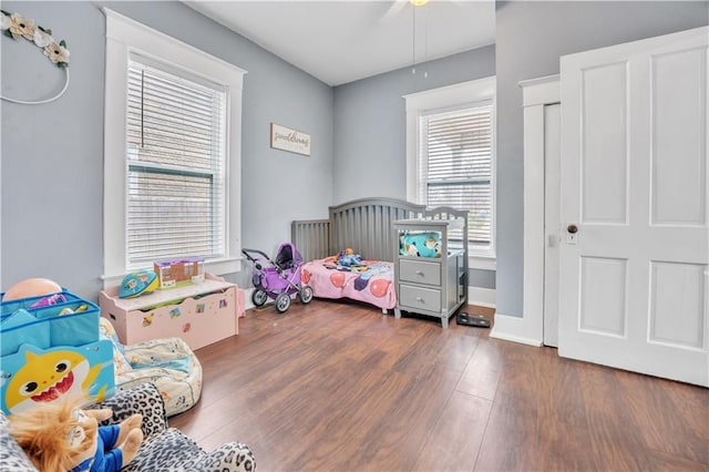 bedroom featuring ceiling fan, baseboards, and wood finished floors