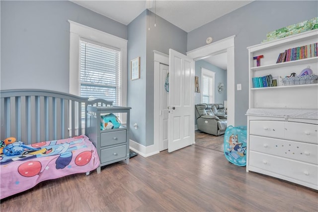 bedroom with baseboards and wood finished floors