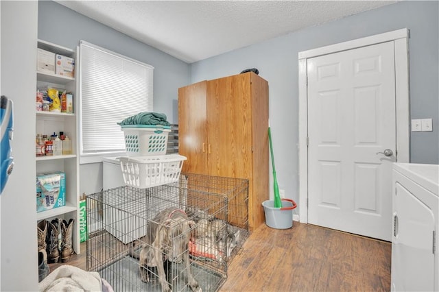 misc room with a textured ceiling, washer / dryer, and wood finished floors