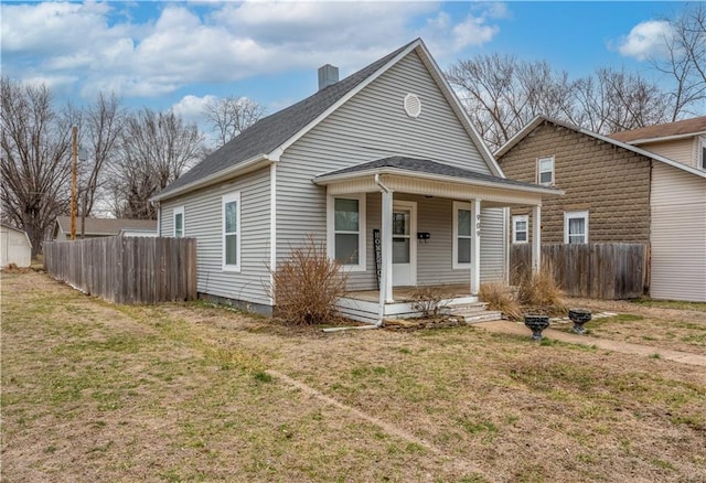 bungalow with covered porch, a front yard, and fence