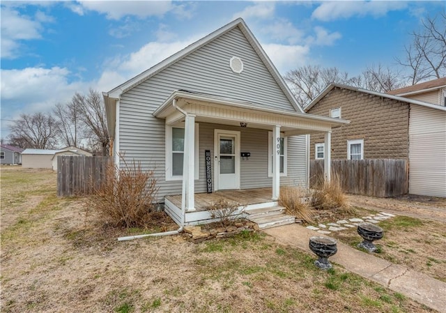 bungalow-style house featuring covered porch and fence