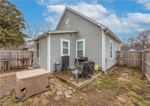 back of house with a wooden deck and a fenced backyard