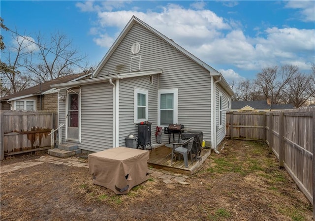 back of house featuring a wooden deck, a fenced backyard, and entry steps