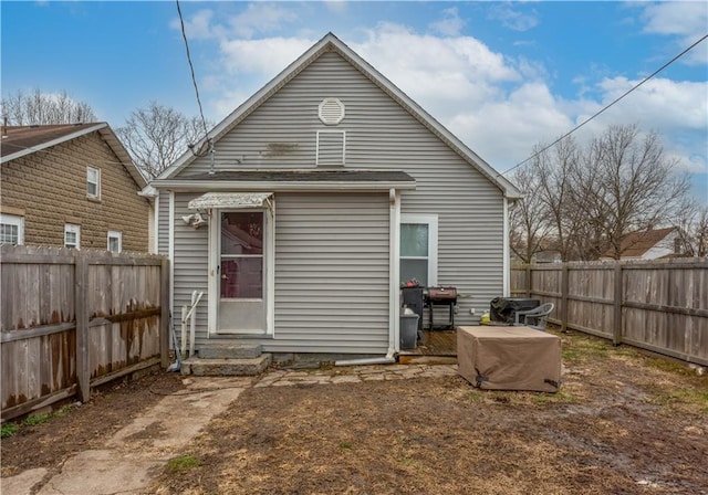 back of property with a fenced backyard and entry steps