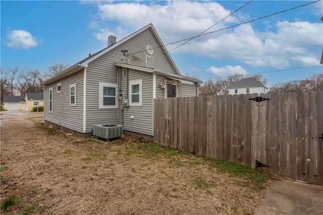 view of home's exterior featuring central air condition unit and fence