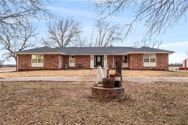 single story home featuring brick siding and a chimney