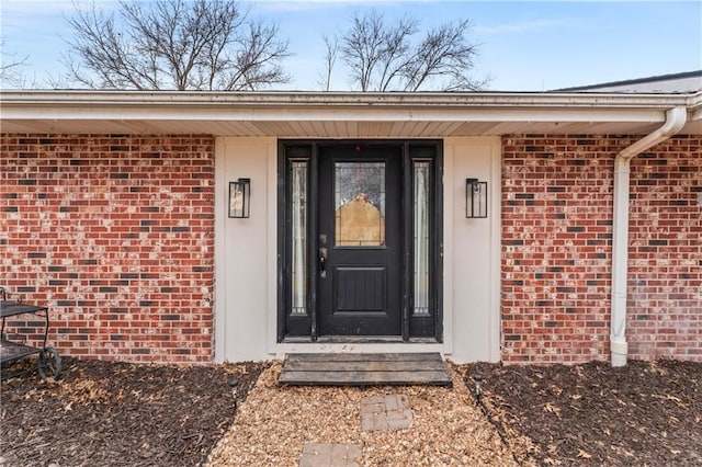 doorway to property with brick siding