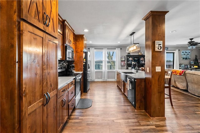 kitchen with dark wood-type flooring, light countertops, open floor plan, and stainless steel appliances