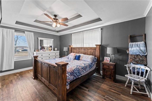 bedroom featuring dark wood-style floors, crown molding, a raised ceiling, and baseboards