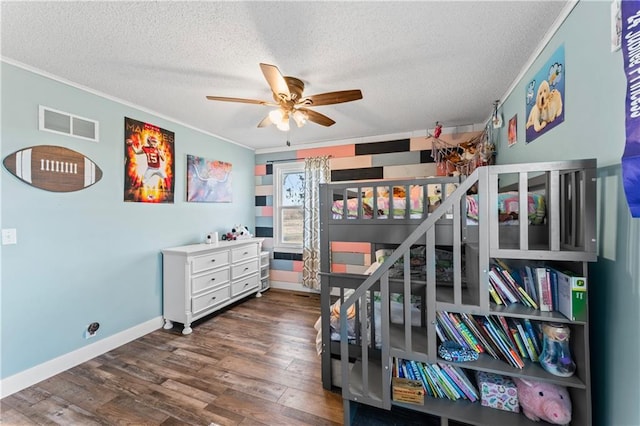 bedroom with visible vents, a textured ceiling, wood finished floors, and crown molding