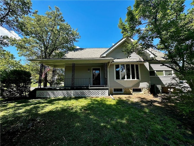 rear view of house featuring a lawn and covered porch