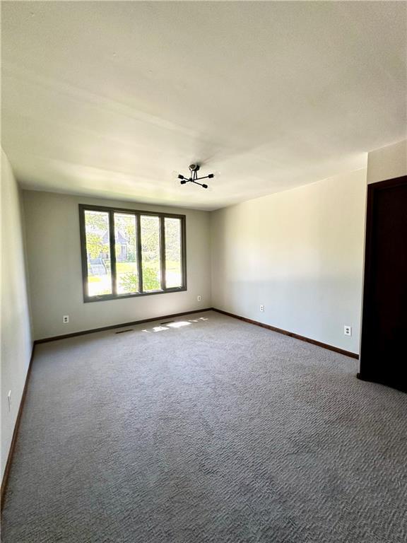 carpeted spare room featuring baseboards