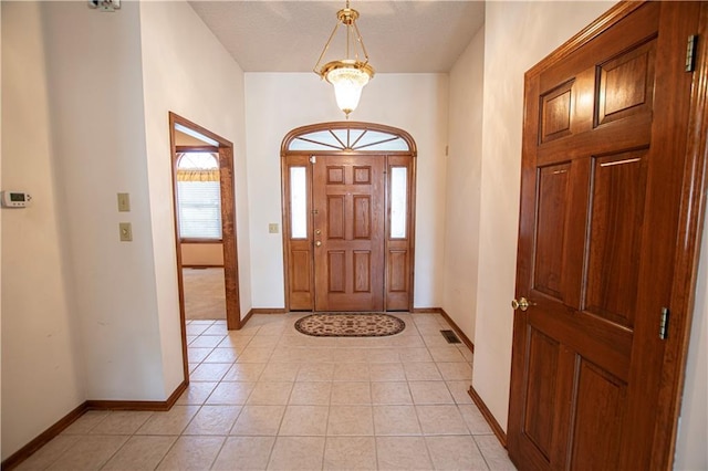 entrance foyer featuring light tile patterned floors, visible vents, and baseboards