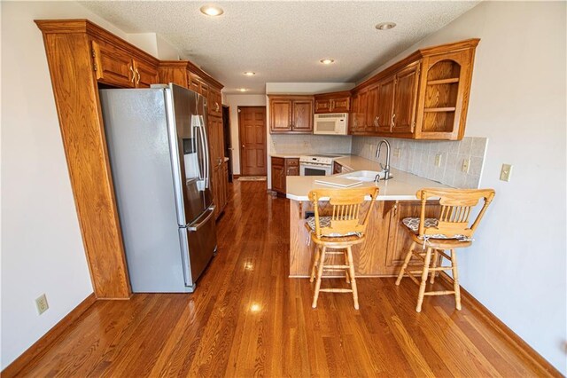 22513 E 33rd St S, Blue Springs, MO 64015 - kitchen featuring a sink, dark wood-style floors, white appliances, a peninsula, and light countertops