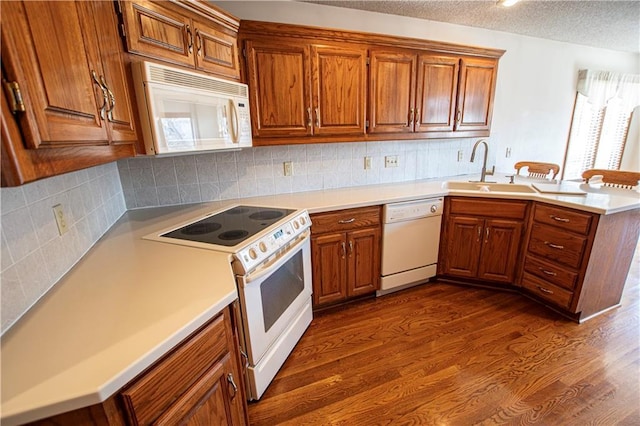 22513 E 33rd St S, Blue Springs, MO 64015 - kitchen featuring white appliances, a peninsula, brown cabinets, and a sink