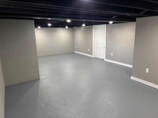 finished basement featuring concrete block wall and baseboards