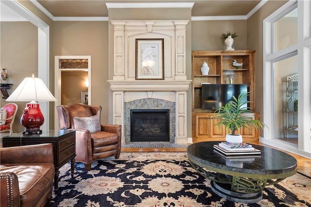 living area featuring a fireplace, wood finished floors, and ornamental molding