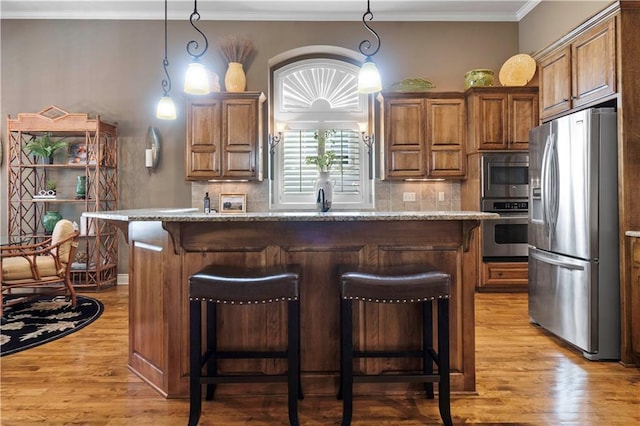 kitchen featuring light wood finished floors, stainless steel appliances, and tasteful backsplash