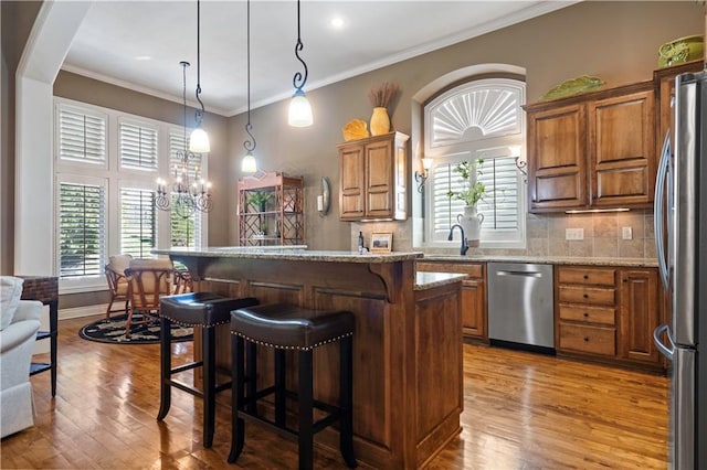 kitchen with hardwood / wood-style flooring, brown cabinetry, and stainless steel appliances