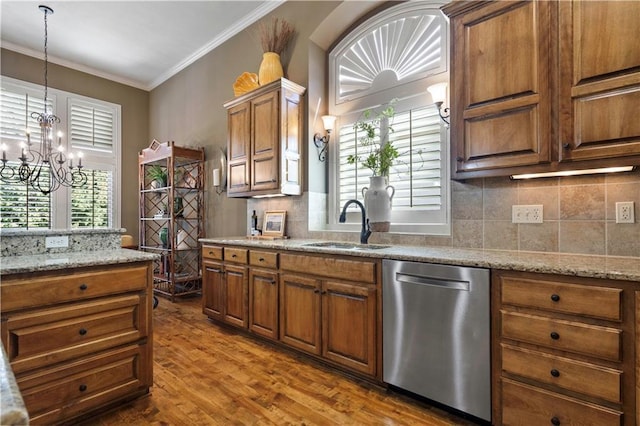 kitchen with a sink, brown cabinets, stainless steel dishwasher, and ornamental molding