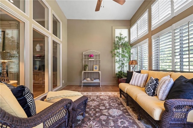 living area with tile patterned flooring, a ceiling fan, and baseboards