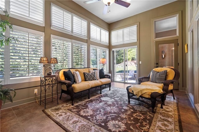 interior space with tile patterned flooring, a high ceiling, baseboards, and ceiling fan