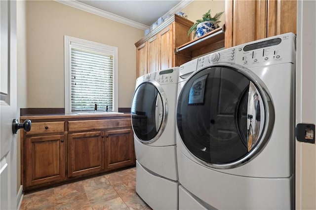 washroom with crown molding, cabinet space, independent washer and dryer, and a sink