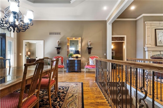 dining area featuring visible vents, ornamental molding, wood finished floors, baseboards, and a chandelier