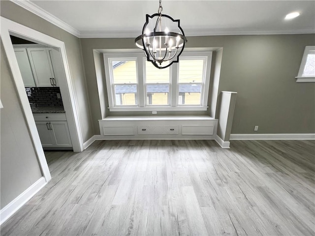 unfurnished dining area with light wood-type flooring, baseboards, and ornamental molding