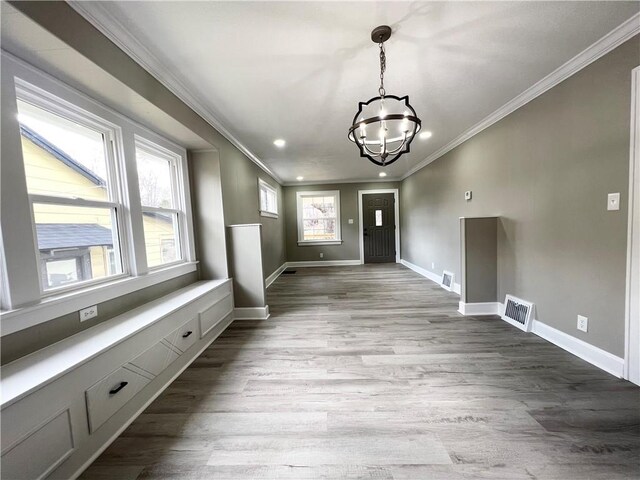 interior space with a wealth of natural light, visible vents, and crown molding