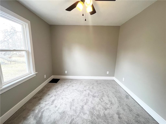 spare room featuring carpet flooring, a healthy amount of sunlight, baseboards, and ceiling fan