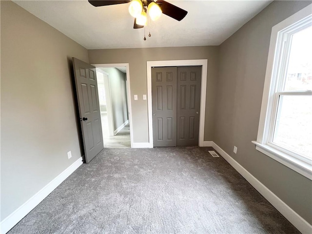 unfurnished bedroom featuring a closet, carpet flooring, ceiling fan, and baseboards